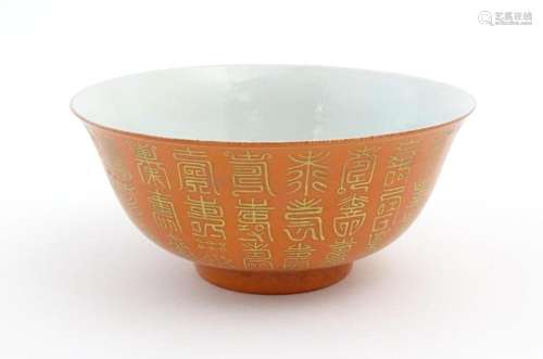 A Chinese bowl with an orange ground and gilt char…