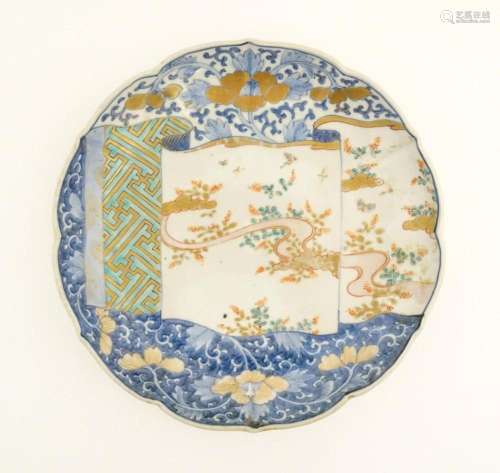 A Japanese dish with shaped rim decorated with scr…