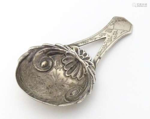 A Geo III silver caddy spoon with engraved decorat…