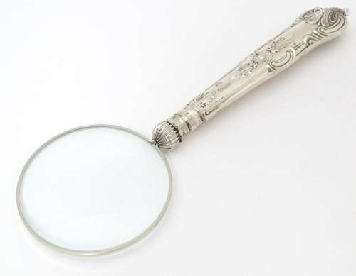 A silver handled magnifying glass. Approx. 6 1/4"…