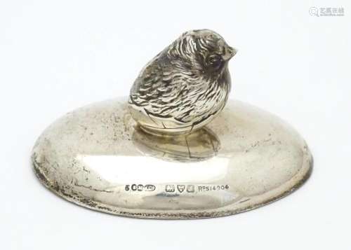 A silver paperweight of ovoid form surmounted by m…