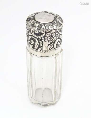 A glass salts bottle with embossed silver lid, hal…