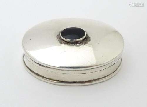 A silver pill box of oval form with inset coloure…