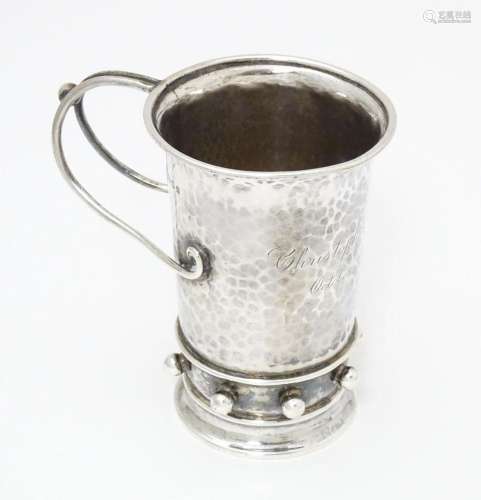 An Arts & Crafts silver christening mug with hamme…