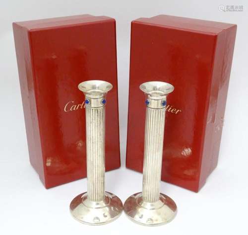 A pair of silver plate candlesticks of fluted colu…