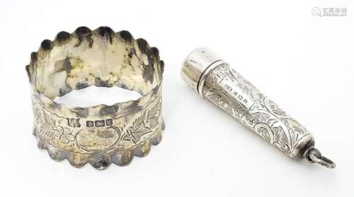 A silver napkin ring with engraved floral and foli…