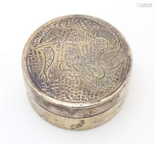 A silver pill box with engraved Oriental dragon de…