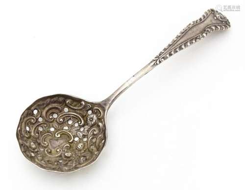 A silver sifter spoon with embossed and pierced de…