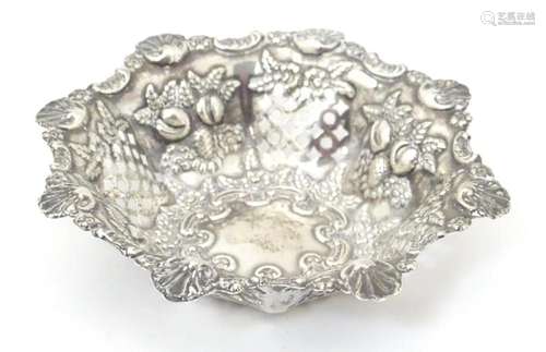 A silver pin dish with pierced and embossed decora…