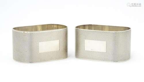 A pair of silver napkin rings of ovoid form with e…