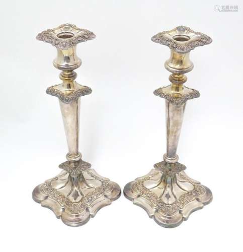 A pair of silver plate candlesticks with floral an…