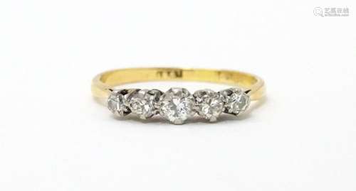 An 18ct gold ring set with five diamonds. Ring siz…