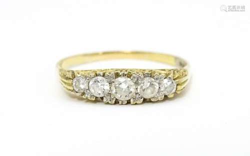 A 9ct gold ring set with five white stones. Ring s…