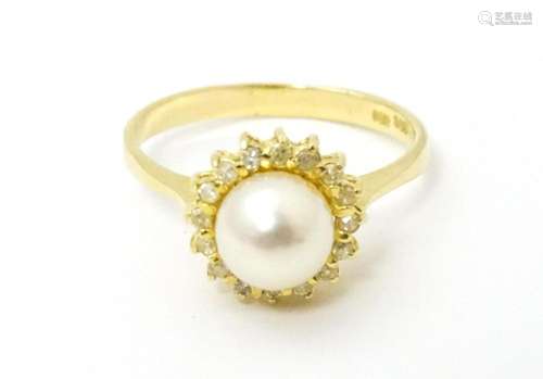 A 14ct gold ring set with central pearl bordered …