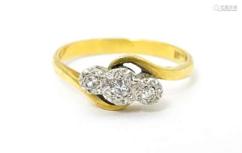 An 18ct gold ring with platinum set diamond trio. …