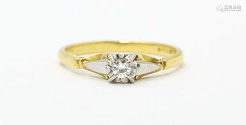 An 18ct gold ring set with central diamond solitai…