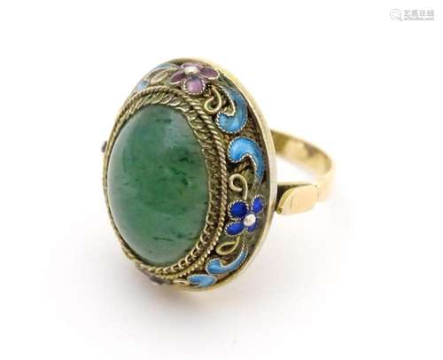 A 14ct gold ring set with central jadeite cabochon…