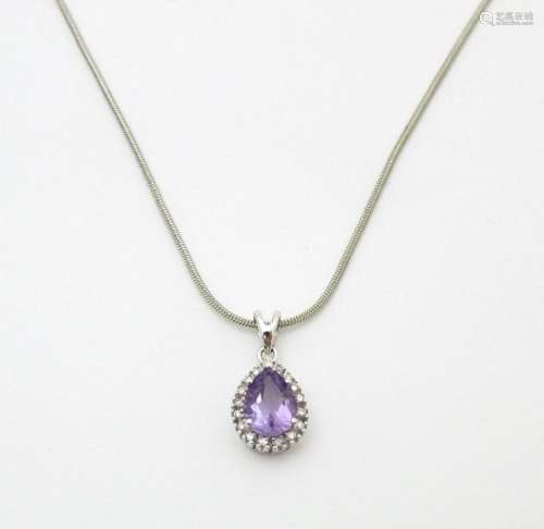 A 9ct white gold pendant set with amethyst bordere…