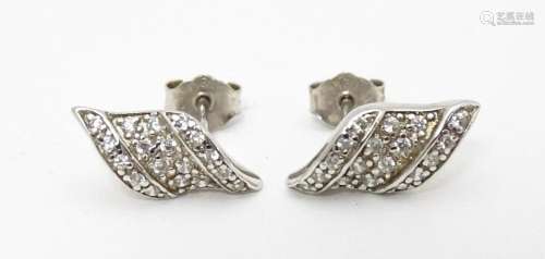 A pair of silver stud earrings set with white ston…
