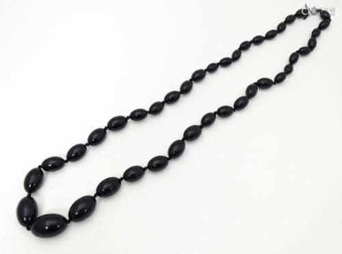 A vintage graduated black amber coloured bead neck…