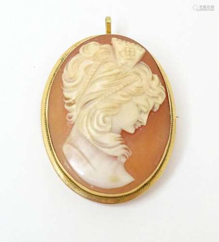 A carved cameo brooch within a gold mount. Approx …