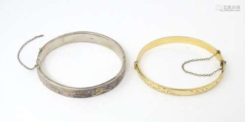 A silver bracelet of bangle form with engraved aca…