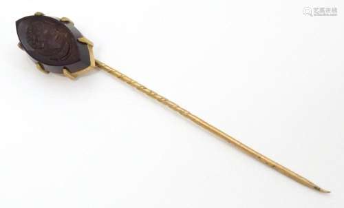 A yellow metal stick pin with carved intaglio to t…