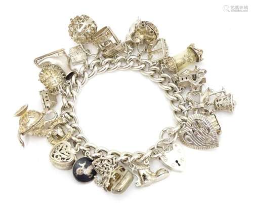 A silver charm bracelet set with a large quantity …