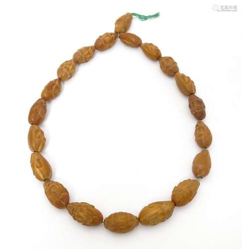 An Oriental necklace of Hediao carved nut beads. A…