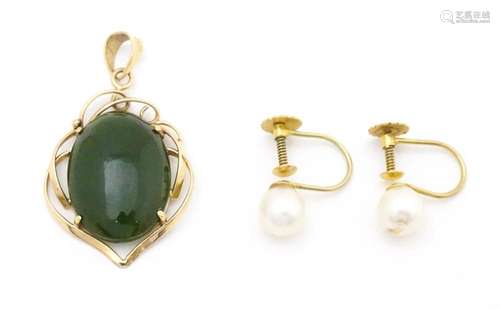 A yellow metal pendant set with green stone caboch…