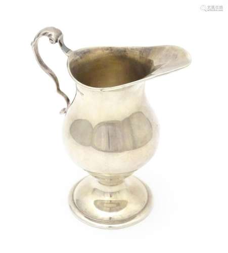 A silver cream jug with loop handle and pedestal f…