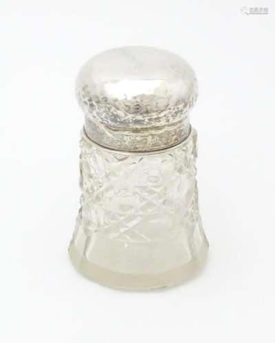 A cut glass dressing table jar with hammered silve…