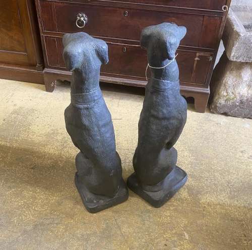 A pair of painted cast stone seated greyhound garden ornamen...