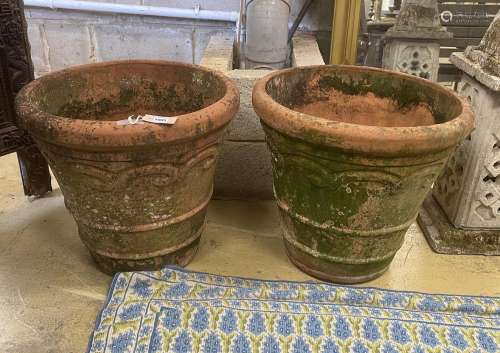A pair of circular weathered terracotta garden planters, dia...