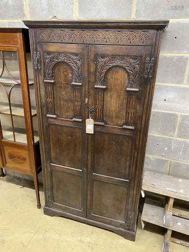 An 18th century style carved oak hall cupboard, width 97cm, ...