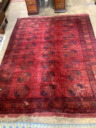 A Bokhara red ground carpet, worn and holed, 286 x 214cm