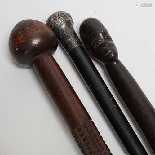 A silver topped walking cane and two African carved wood can...