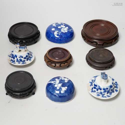 A group of Chinese wooden stands and ceramic lids