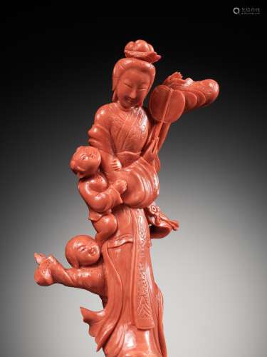 A CHINESE CARVED RED CORAL FIGURE OF A MEIREN WITH BOYS