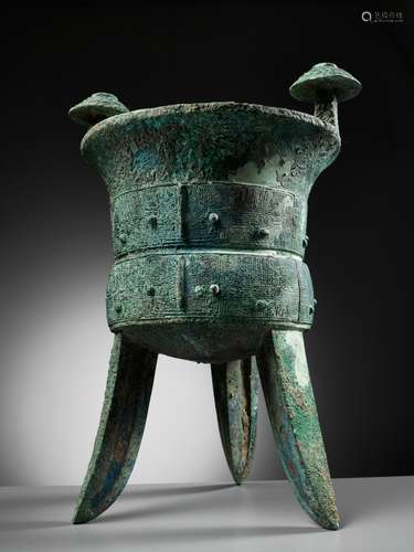 AN EXCEPTIONALLY LARGE AND MASSIVE BRONZE RITUAL TRIPOD WINE...