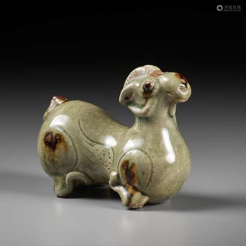 A RARE IRON-SPLASHED ‘YUE’ FIGURE OF A RECUMBENT RAM, WESTER...