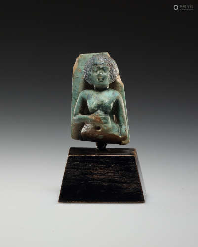 AN EGYPTIAN FAIENCE AMULET OF A WOMAN WITH SHORT-HAIRED WIG ...
