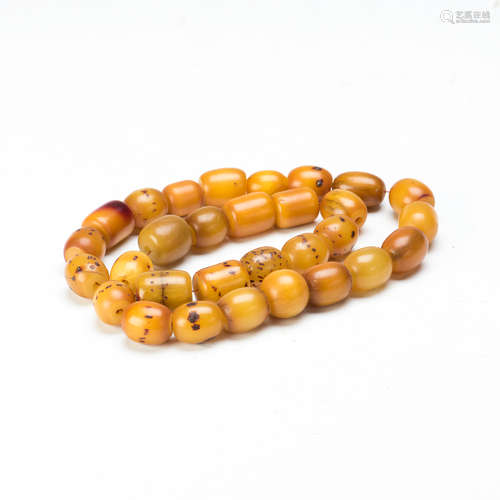 A STRAND OF BEESWAX BEADS, 30 BEADS