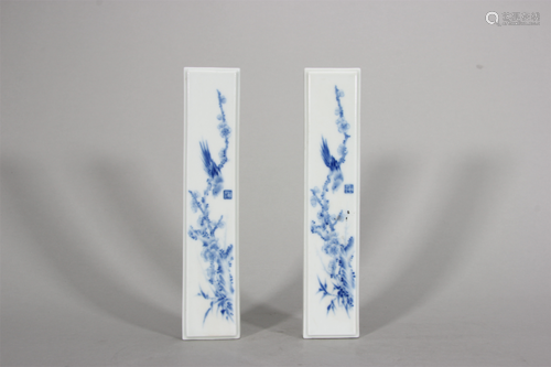 A pair of blue and white flower and bird porcelain paperweig...