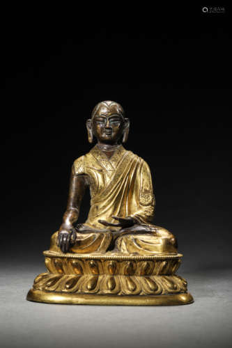 A GILT BRONZE FIGURE OF GURU