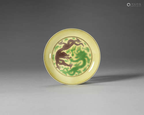 A yellow-ground green and aubergine-enamelled 'dragon' saucer dish.  Kangxi six-character mark and of the period