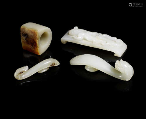 Two pale green jade belt hooks, a scroll form rest and a thumb ring.  19th/20th century