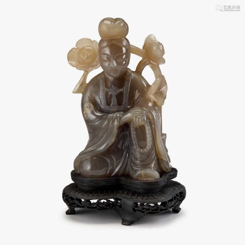 A Chinese agate carving of Guanyin on bended knee with flowering branch, late qing dynasty