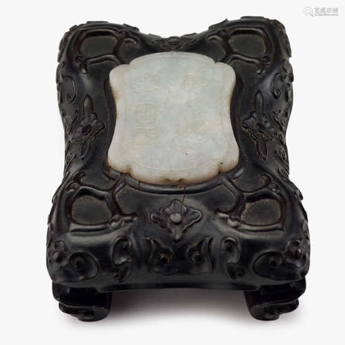 A Chinese white jade pendant set into a carved hardwood stand, qing dynasty