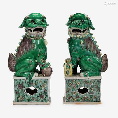 A pair of Chinese sancai glazed porcelain fu lions seated on raised pedestals, republic period